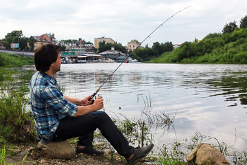 A man with a beard is fishing in the river