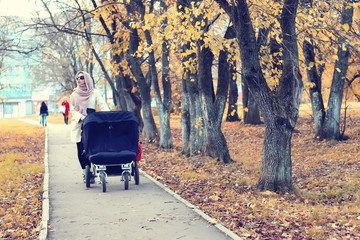 mother in a park stroller autumn