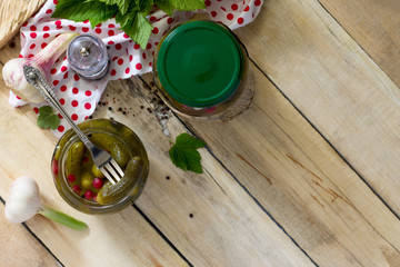 Marinated cucumbers gherkins. Marinated pickled cucumbers with red currant berries and spices on the kitchen wooden table. Top view with copy space.