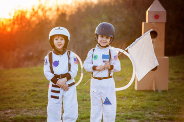 Two adorable children, playing in park on sunset, dressed like astronauts © Tomsickova