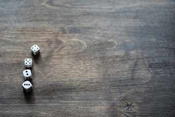 White dices on a brown wooden texture table