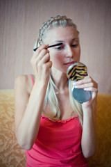 The girl puts makeup on her face