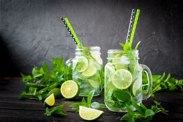 Mojito cocktail with lime and mint in highball glass on a black stone background Copy space