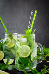 Mojito cocktail with lime and mint in highball glass on a black stone background Copy space