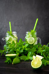 Mojito cocktail with lime and mint in highball glass on a black stone background Copy space