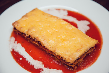 Tasty serving of traditional Italian lasagne with spicy tomato based ground beef.