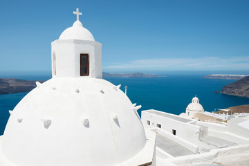 White cupola of church with Aegean sea and volcanic island in background, Santorini, Greece