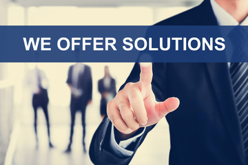 Businessman hand touching WE OFFER SOLUTIONS message on virtual screen
