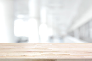 Wood table top on blurred white gray background of building hallway
