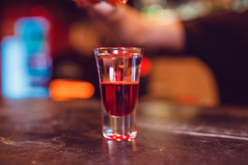 A cocktail made by layers. Shot at the bar.
