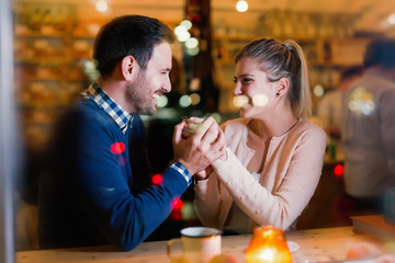 Happy couple talking at bar and having date