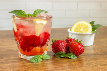 Glass of cold tea with mint,strawberry,lemon, on table