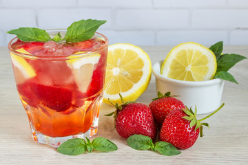 Fototapeta na wymiar Glass of cold tea with mint,strawberry,lemon, on table