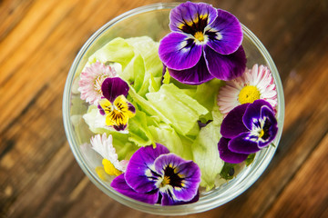 Obraz na płótnie Canvas Fresh green salad with herbs and garden flowers. Healthy food concept