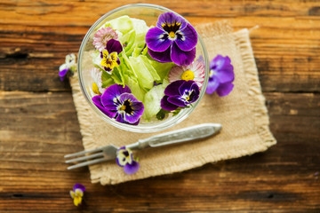 Close up salad leaves garden herbs and edible flowers. Healthy nutrition. Food background