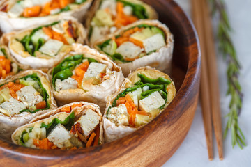 Healthy vegan tofu tortilla wraps with tofu and vegetables, top view. Love for a healthy raw food concept.
