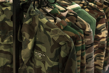 Jacket military style hanging on clothes rack.