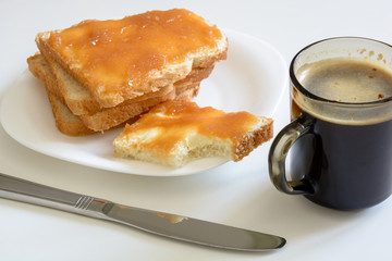 Tasty breakfast. Toasts with butter and jam on a plate. Cup of coffe.