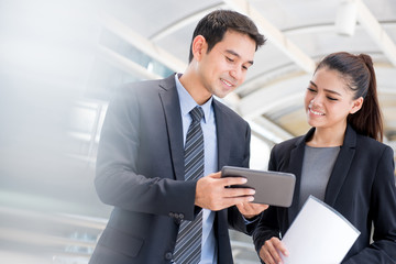 Businessman and businesswoman looking at tablet pc