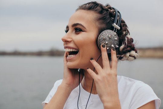 Portrait of a smiling woman wearing spiked headphones