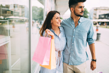 Happy attractive loving couple enjoy shopping together