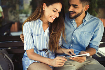 Young attractive couple on date sitting on bench