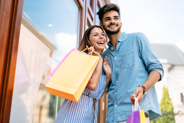 Happy attractive loving couple enjoy shopping together