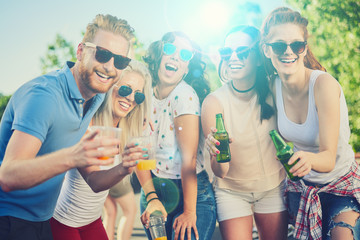 Friends drinking, cheering, dancing and partying outdoors