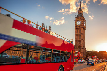 Big Ben with double decker bus against sunset in London, England, UK