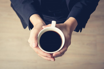 Woman hands holding coffee cup with black coffee