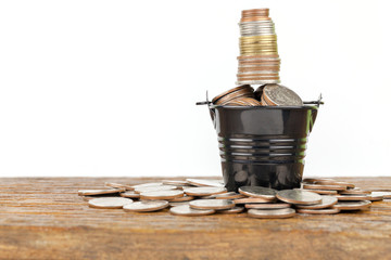 Thai baht coins on  small zinc bucket on  wood background © SINSU1980