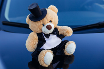 Teddy bear in tuxedo wearing a bow tie and a hat
