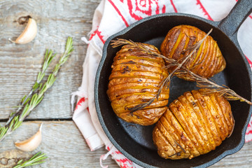 Baked potatoes with rosemary in a cast-iron frying pan.