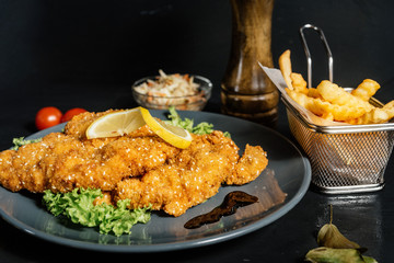 Fried veal chop as stylish wiener schnitzel served with french fries and vegetables