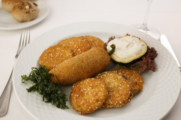 Breaded and fried red bell pepper and eggplant arranged on a plate, Traditional dish in elegant setting, Selective focus with soft light