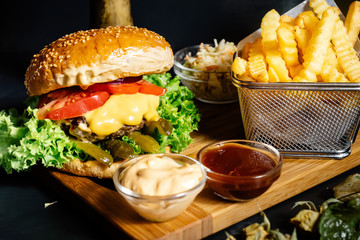 Tasty grilled beef burger with fresh vegetables and french fries served hot at local bistro