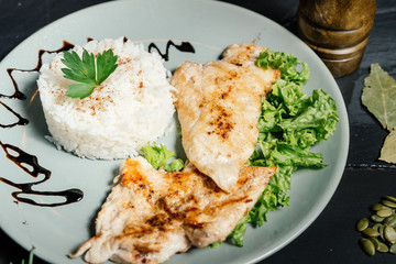 Close up details of grilled chicken breast with risotto and parsley
