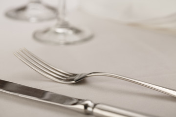 Fork and table knife with wineglass arranged in elegant setting, Selective focus with soft light