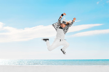 Fashion child jumping over sky background.