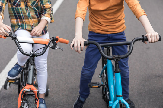 Cropped Shot Of Casual Kids Riding Bicycles On The Street