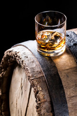 Glass of good whisky with ice in the distillery basement
