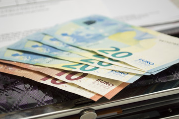 Money bills lying on a women's purse. Cash on small expenses. Women's finances.