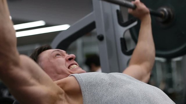 Strong athlete lifting the barbell at the gym, weightlifting, sport
