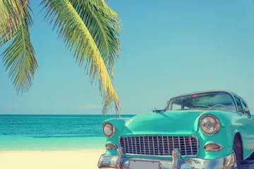 Tuinposter Klassieke auto op een tropisch strand met palmboom, vintage proces © Delphotostock