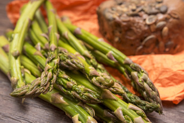 Green Asparagus (Asparagus officinalis) with bread on wooden table