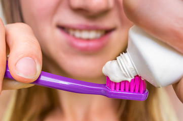 Woman brushing her teeth with toothbrush in the morning