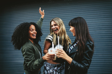 Group of female friends having fun with ice coffee