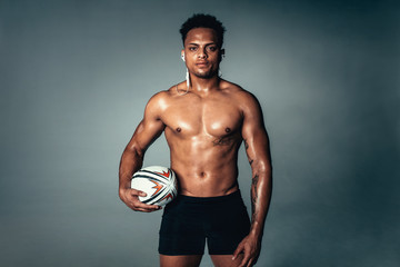 Fototapeta na wymiar Fit young man holding rugby ball