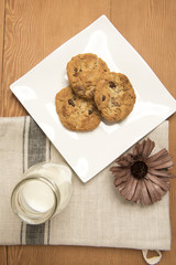 Chocolate chip cookies with a small glass bottle of milk 