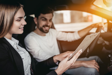 Salesperson with customer in car dealership